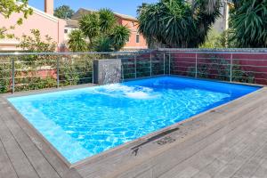 uma piscina com água azul em frente a um edifício em Villa Nitsa em Corfu Town