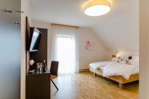 a bedroom with a bed and a desk and a window at Gästezimmer Das Hambammer in Heimschuh