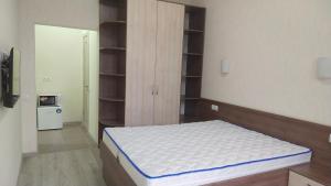 a bedroom with a bed in a room with shelves at Апартаменты на Соборном с видом на парк in Zaporozhye