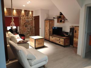 uma sala de estar com um sofá e uma televisão em Los Tres Monos em Ávila