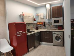 uma cozinha com um frigorífico vermelho e uma máquina de lavar roupa em Los Tres Monos em Ávila