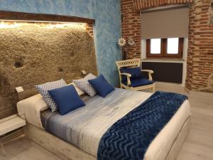 Un dormitorio con una cama grande con almohadas azules. en Los Tres Monos, en Ávila