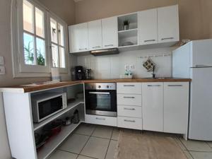 a kitchen with white cabinets and a white refrigerator at Asprokavos beach apartment and studio in Kavos