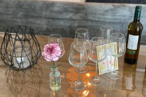 una mesa con copas de vino y una flor en un jarrón en Warm welkom! Zeer ruime privé studio met tuin en Harlingen
