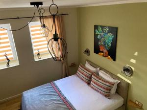 ein Schlafzimmer mit einem Bett und zwei Fenstern in der Unterkunft Diva Garden Apartment in Plowdiw