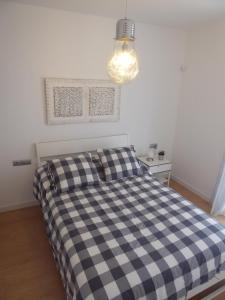 a bedroom with a bed with a checkered blanket at Norasuites28 in La Laguna