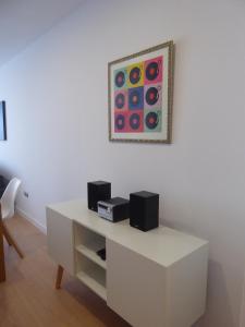 a white table with two speakers and a picture on the wall at Norasuites28 in La Laguna