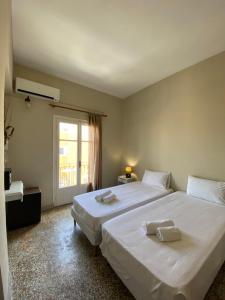 a bedroom with a large white bed and a window at Pansion Roulis in Mesongi