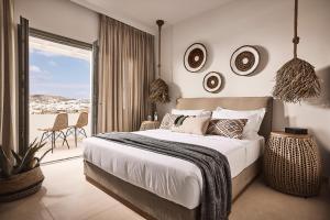 a bedroom with a large bed and a balcony at Nival Boutique Hotel in Sifnos