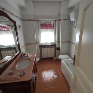 a bathroom with a sink and a toilet and a mirror at Camaga in LʼAquila