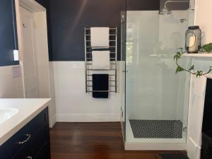 Un baño con ducha de cristal con lavabo. en Warders Cottage: Iconic Cottage in the Heart of Freo, en Fremantle 29 fotos más