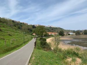 a winding road next to a river with houses at Apartamento la Ribera in Suances