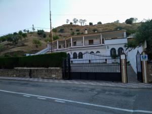a white house with a gate on the side of a road at Alojamiento Árdales in Frailes