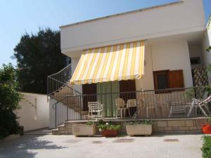 a house with a yellow and white awning on a balcony at Casa Claude in Casalabate