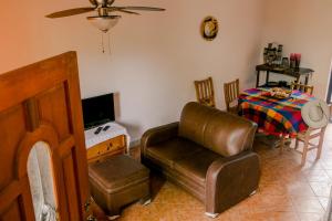 Casa Sofi & Martín, cozy Mexican home في لو دي ماركوس: غرفة معيشة مع كرسي جلدي وطاولة
