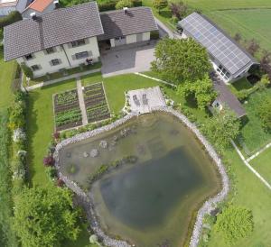 an aerial view of a house with a pond at Ferienwohnung Helmberger in Burgkirchen in Burgkirchen an der Alz