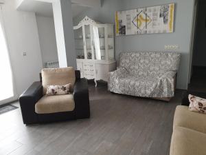 sala de estar con sofá y silla en La terraza de Maxi Casa completa en Cuenca