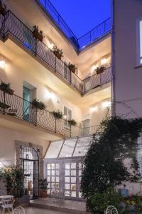 un gran edificio con 2 balcones y un patio en Cas'E Charming House en Caserta