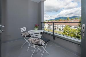 a balcony with two chairs and a table and a window at Lower Lonsdale Aprtment in North Vancouver