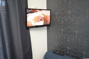 a flat screen tv on a wall in a room at Belvárosi Apartman in Pécs