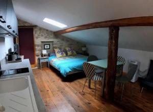 a bedroom with a bed and a table and chairs at Les Gites Du Mazel in champis
