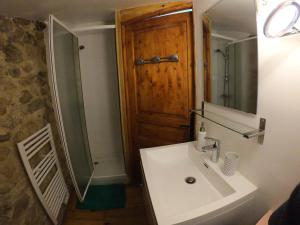 Un baño con lavabo y puerta de madera. en Les Gites Du Mazel, en champis