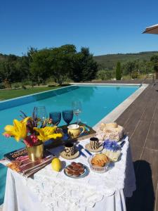 - une table avec de la nourriture à côté de la piscine dans l'établissement Quinta das Regueiras, à Viseu