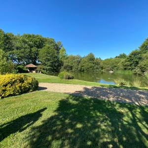 ein Park mit einem See und Bäumen und einem Pfad in der Unterkunft La Fermette Aux Canards in Savigny-Lévescault