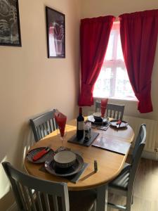 a dining room table and chairs with a red window at Mayfield House Holiday home in Ballinrobe