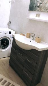 a bathroom with a sink and a washing machine at A casa di Raffaella e Antonio in Surbo +26 photos