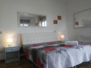 um quarto com uma cama, um espelho e uma janela em Villa Rita em Peschici