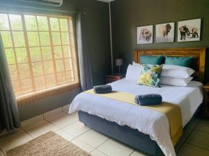 a bedroom with a bed with two pillows on it at Impala Lily in Marloth Park +33 photos