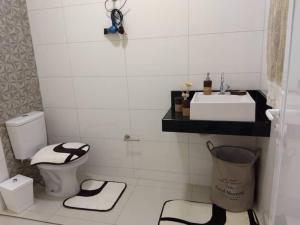een witte badkamer met een wastafel en een toilet bij Cantinho da Florzinha in Foz do Iguaçu