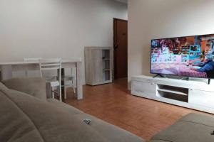 a living room with a couch and a flat screen tv at Beach House, 300 m dal mare, Marina di Massa in Marina di Massa