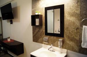 a bathroom with a sink and a mirror at Cabo Tortuga Hotel Boutique in Cabo San Lucas