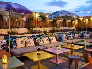a patio with a couch and two tables with umbrellas at Mama Shelter Paris East in Paris