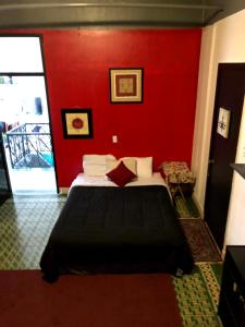a red bedroom with a bed and a red wall at MEDUSA'S HOSTEL in Aguadilla
