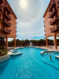 a pool at a hotel with people swimming in it at Flat Partic Hotel Jurere Beach Village in Florianópolis