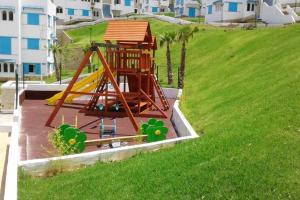 a playground with a slide in a field of grass at Nice 1BR Salon Seaview Pool Mdiq Cabonegro in M'diq