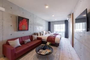 a bedroom with a large bed and a red couch at Tamatsukuri Daifuji Kan in Osaka