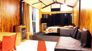 a bedroom with a bed and a couch in a room at Kithul Cottage in Nuwara Eliya