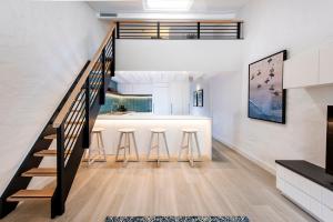 una cocina y comedor con una escalera en una casa en SandCastles Noosa, en Noosa Heads