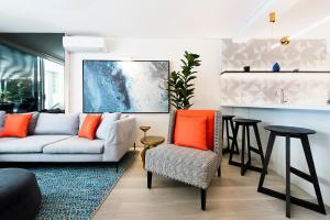 salon z białą kanapą i pomarańczowymi poduszkami w obiekcie SandCastles Noosa w mieście Noosa Heads