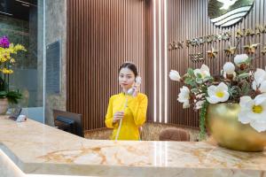 a woman standing at a table talking on a phone at Tan Phuong Nam Hotel & Apartment in Da Nang +68 photos