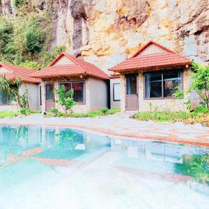 a house with a swimming pool in front of a mountain at Trang An Peaceful Homestay in Ninh Binh