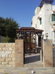 a wooden gazebo in front of a building at no 4and5 Basement Chalets 2 Beds Green Beach on the pool 114b in El Alamein