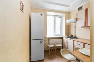 una pequeña cocina con nevera y mesa en City Inn Apartment Sokolniki, en Moscú