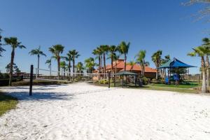 a beach with palm trees and a playground at Share villa with other guests in Davenport