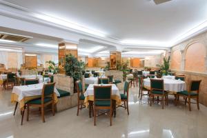 a restaurant with tables and chairs in a room at Hotel Venecia Paguera in Paguera