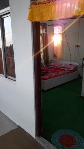 um pequeno quarto com uma cama e um piso verde em Vamoose Rhododendron em Darjeeling
